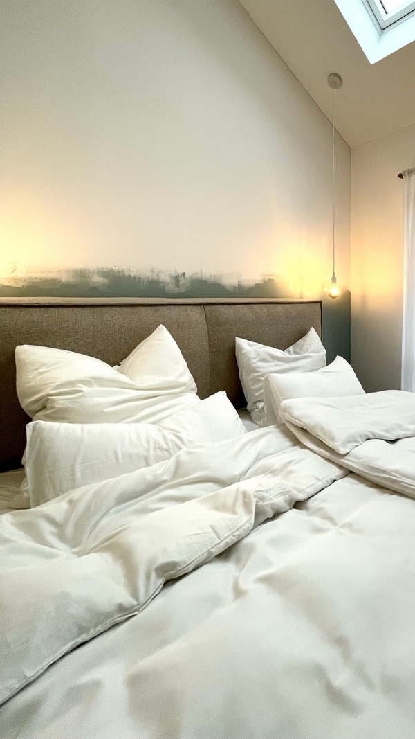 Weiße Lyocell Bettwäsche mit Eukalyptus auf Bett mit Lampen an der Wand 